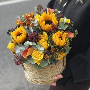 Композиция в сумке "Тональность" из подсолнухов, калл, ягод вибирнума, лимонных роз, скиммии и орхидеи в Дмитрове