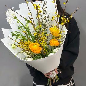 Весенний букет с желтыми ранункулюсами и цветущими ветками форзиции в Дмитрове